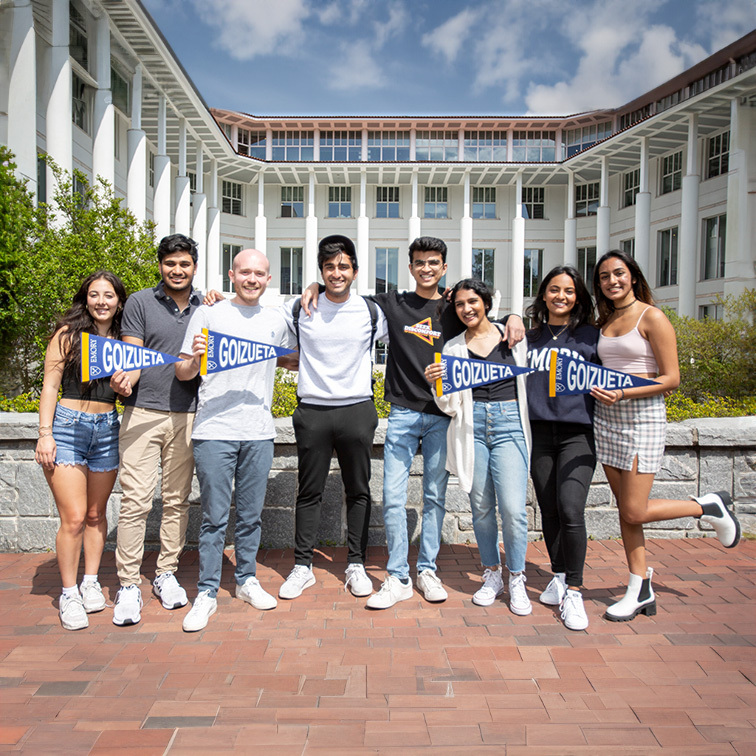 goizueta students posing in a group holding pennants